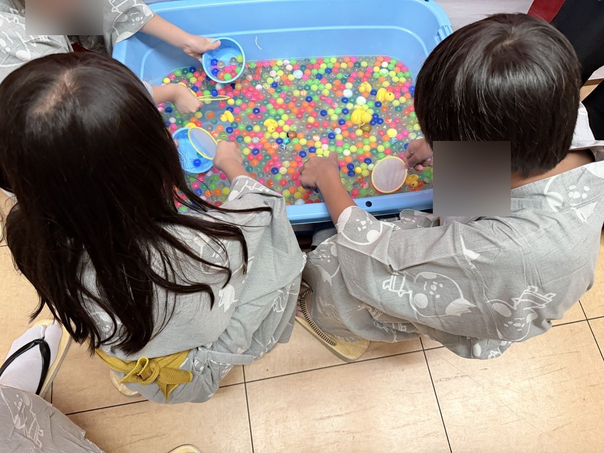 浴衣姿でスーパーボールすくいを楽しむ子どもたち