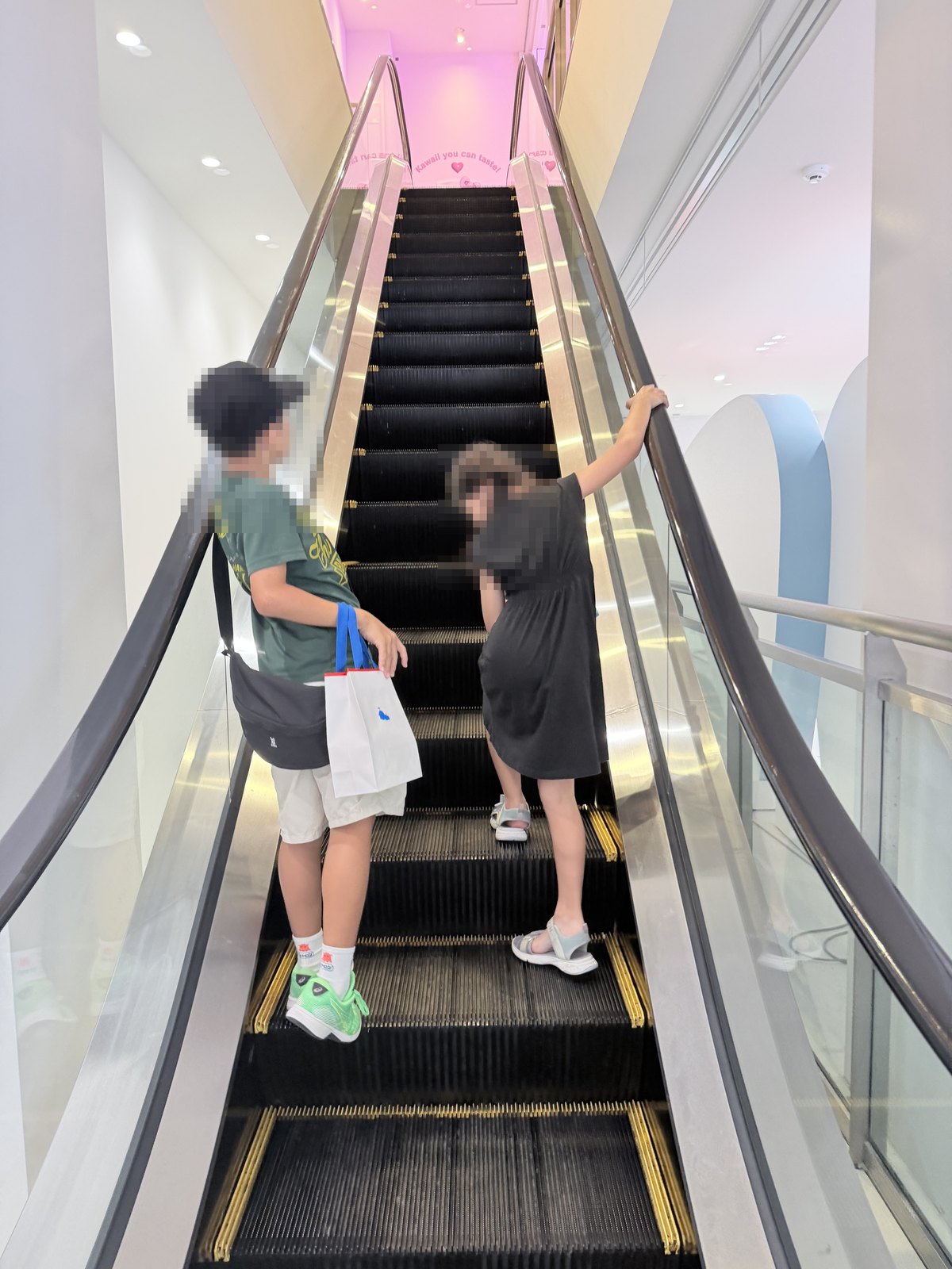 Sanrio原宿店から3階のカフェへ上がるエスカレーター(子どもたちの後ろ姿)
