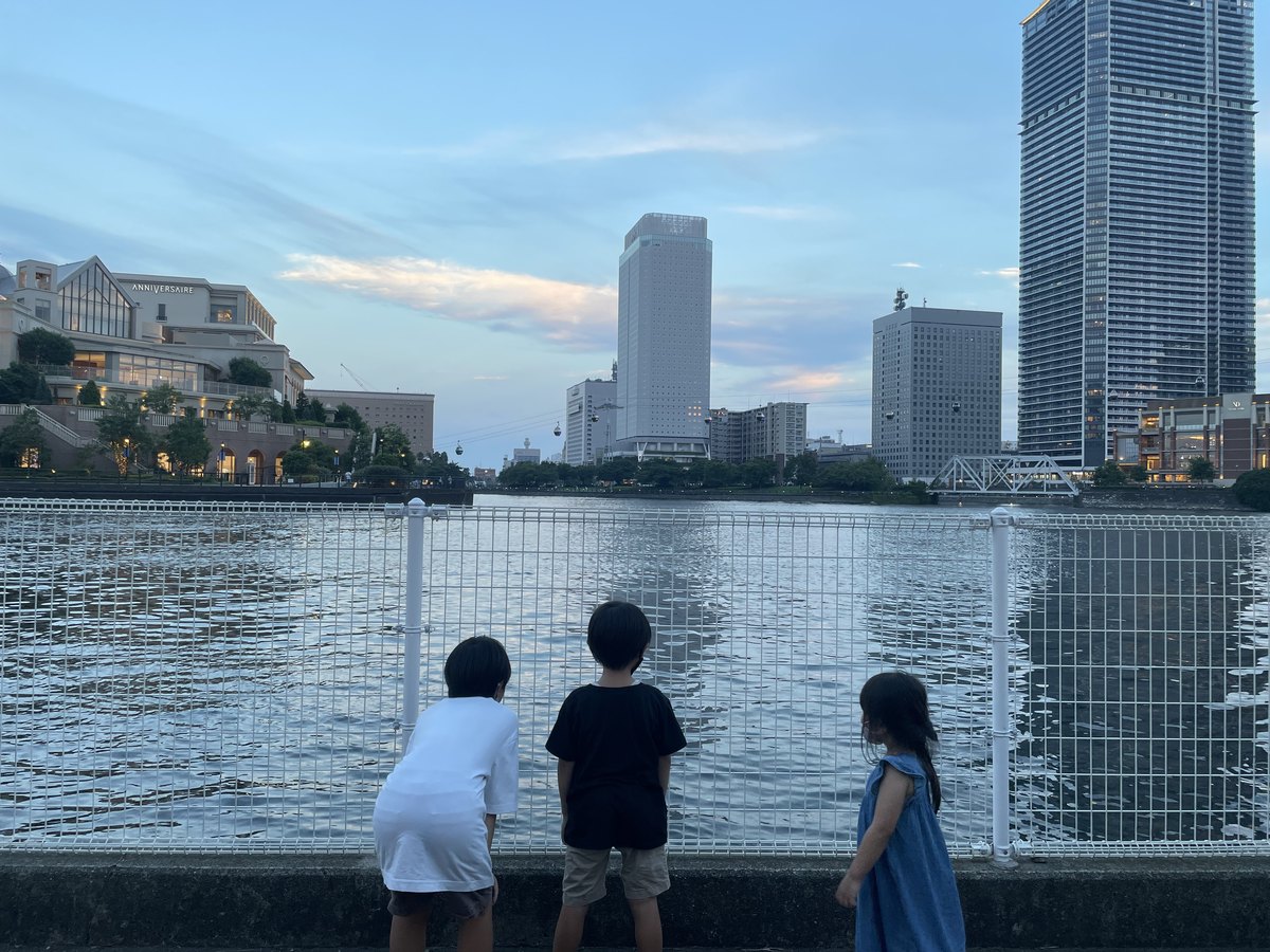 みなとみらいの海辺で観覧車を眺める子どもたち（2022年8月・後ろ姿）