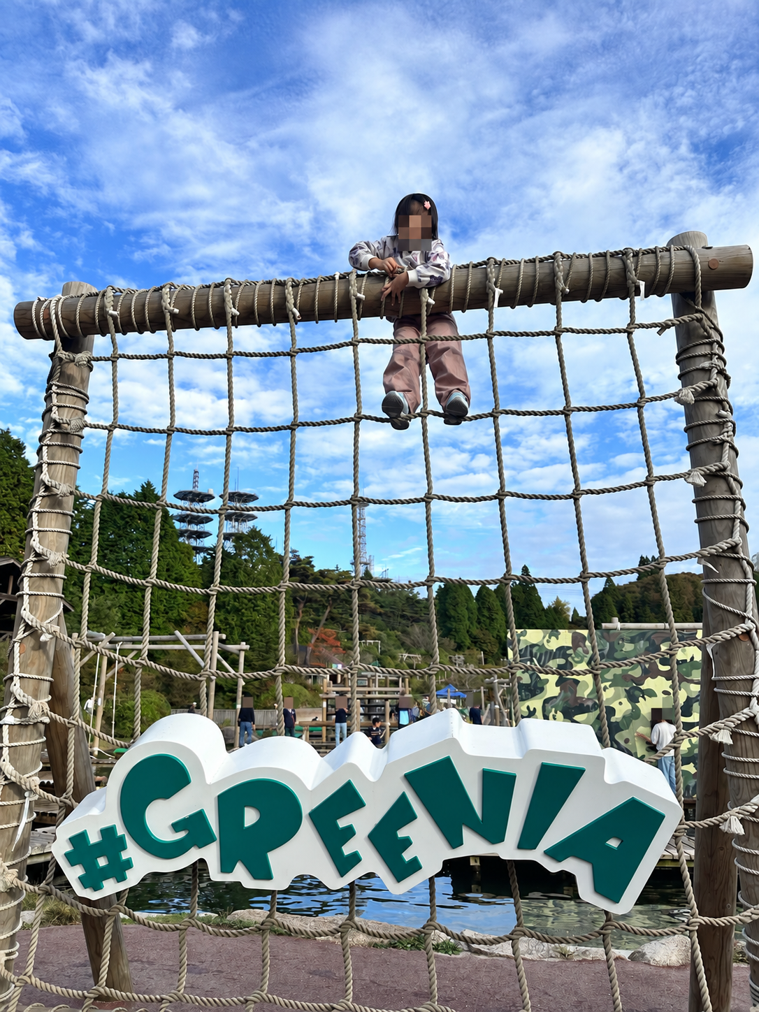 GREENIAのサインとアスレチックで遊ぶ子ども