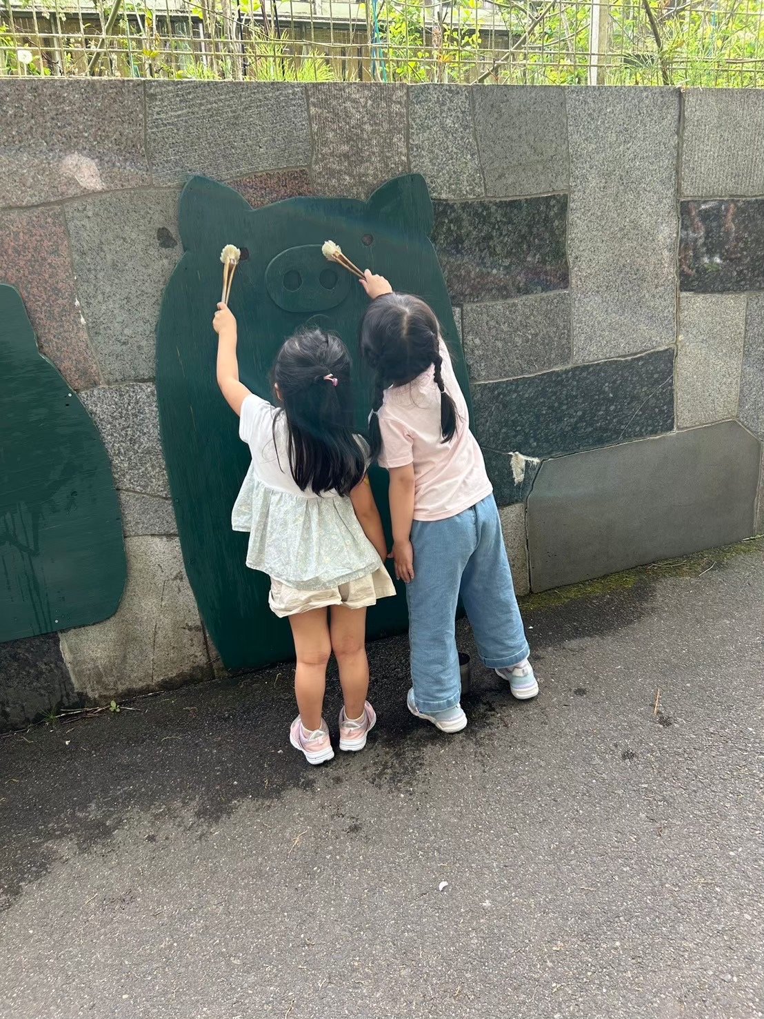 ぶたの壁の前で遊ぶ子どもの後ろ姿
