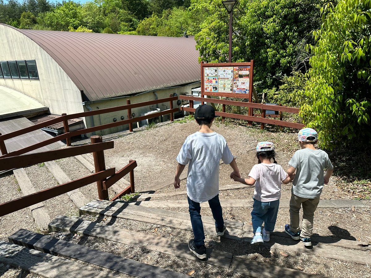 園内の階段を下りる子ども3人の後ろ姿