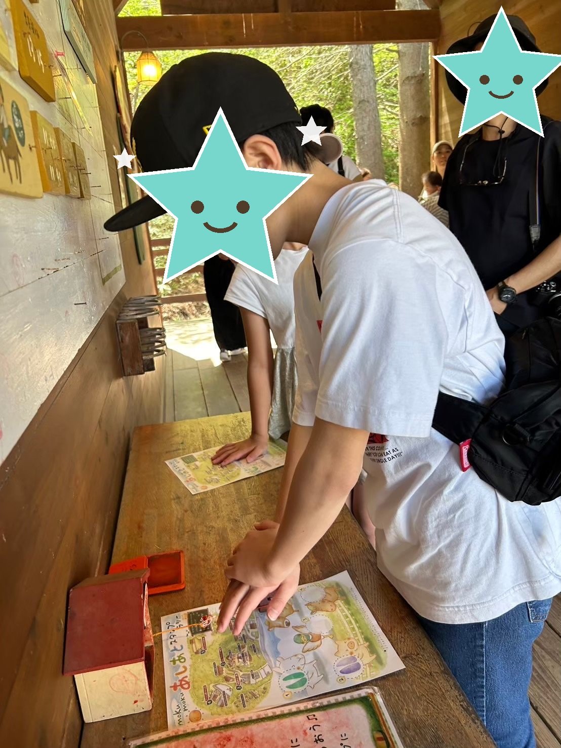 スタンプラリーの台紙にスタンプを押す子ども