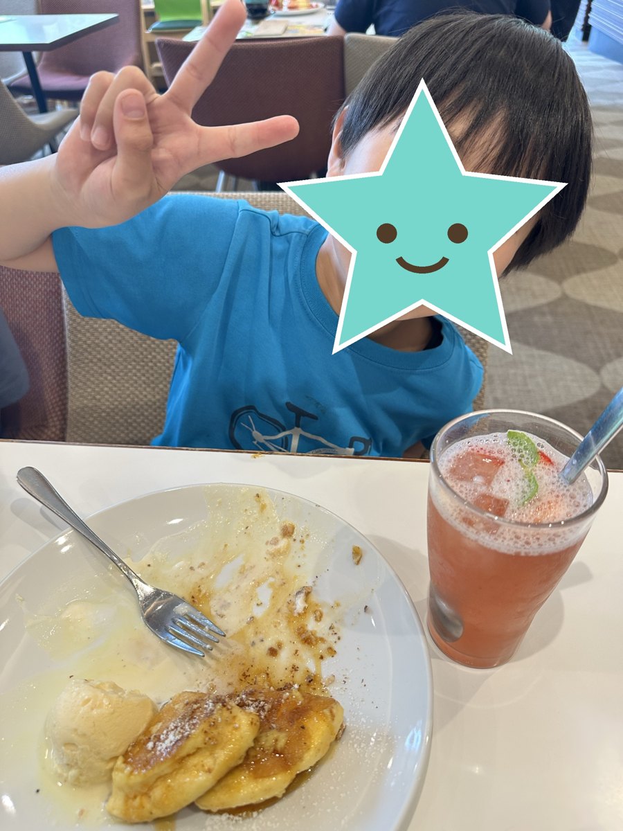 ドリンクとパンケーキの前でピースする息子(顔は星で隠しています)